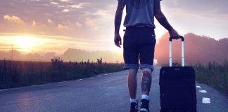 Mann mit Koffer im Sonnenuntergang