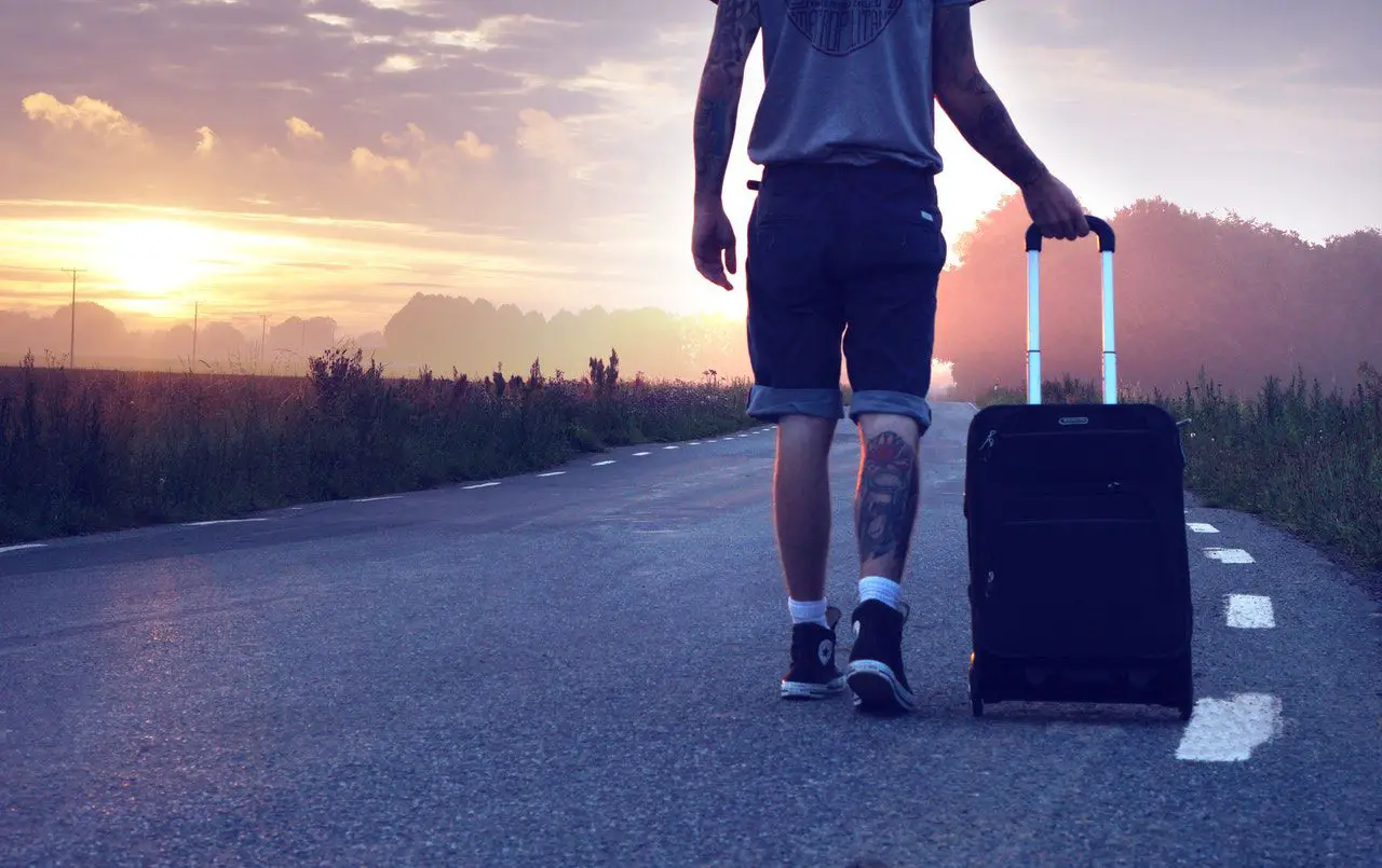 Mann mit Koffer im Sonnenuntergang